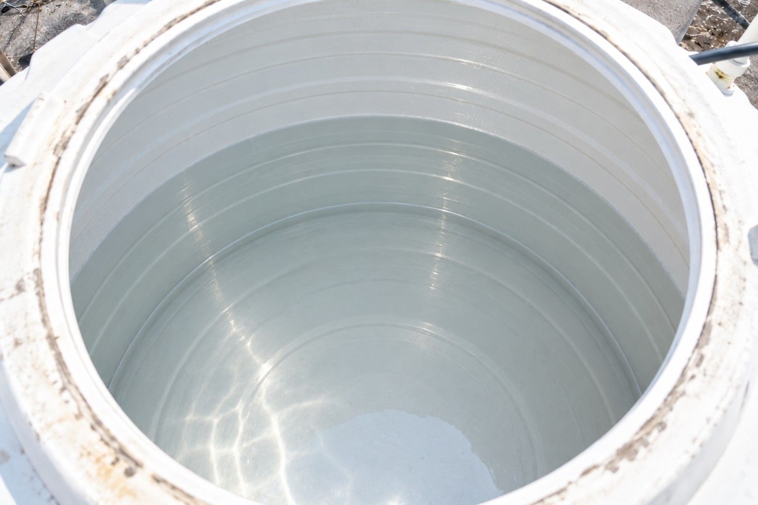 The same water tank after cleaning, with clean white walls and a clear floor